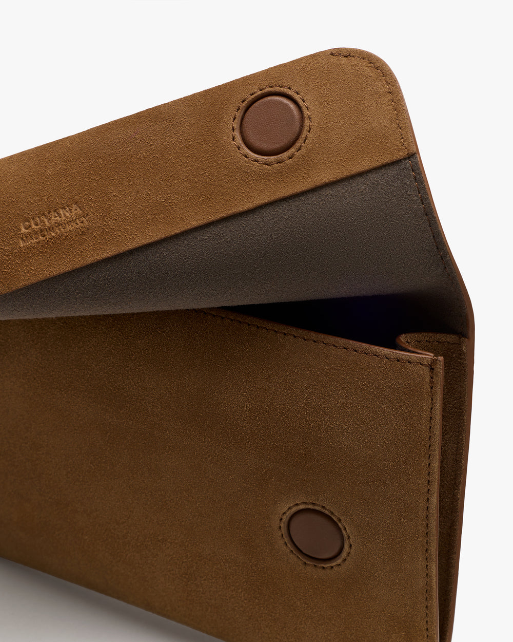 Close-up of an open suede wallet with button closure.