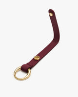 Leather strap with a round metal ring and button.