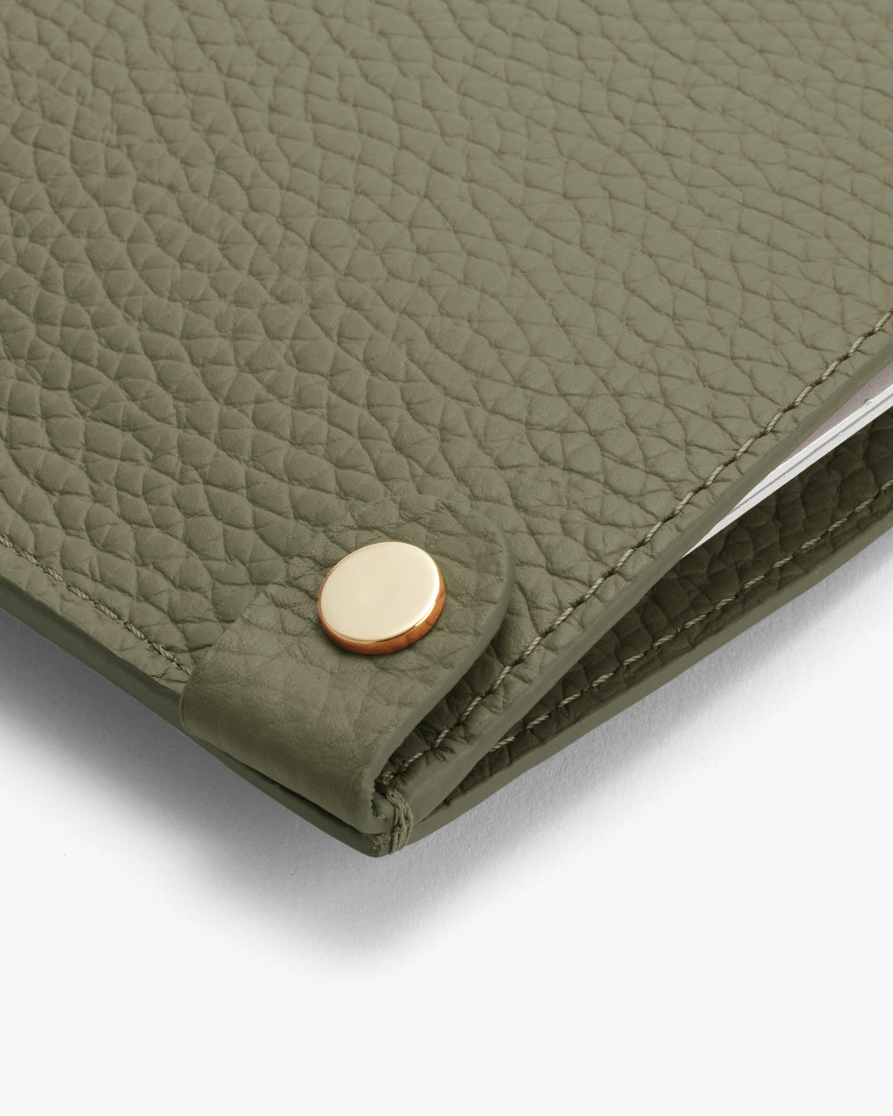 Close-up of a textured leather cover with a metal button stud.