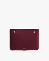 Rectangular clutch with small logo and metallic studs.