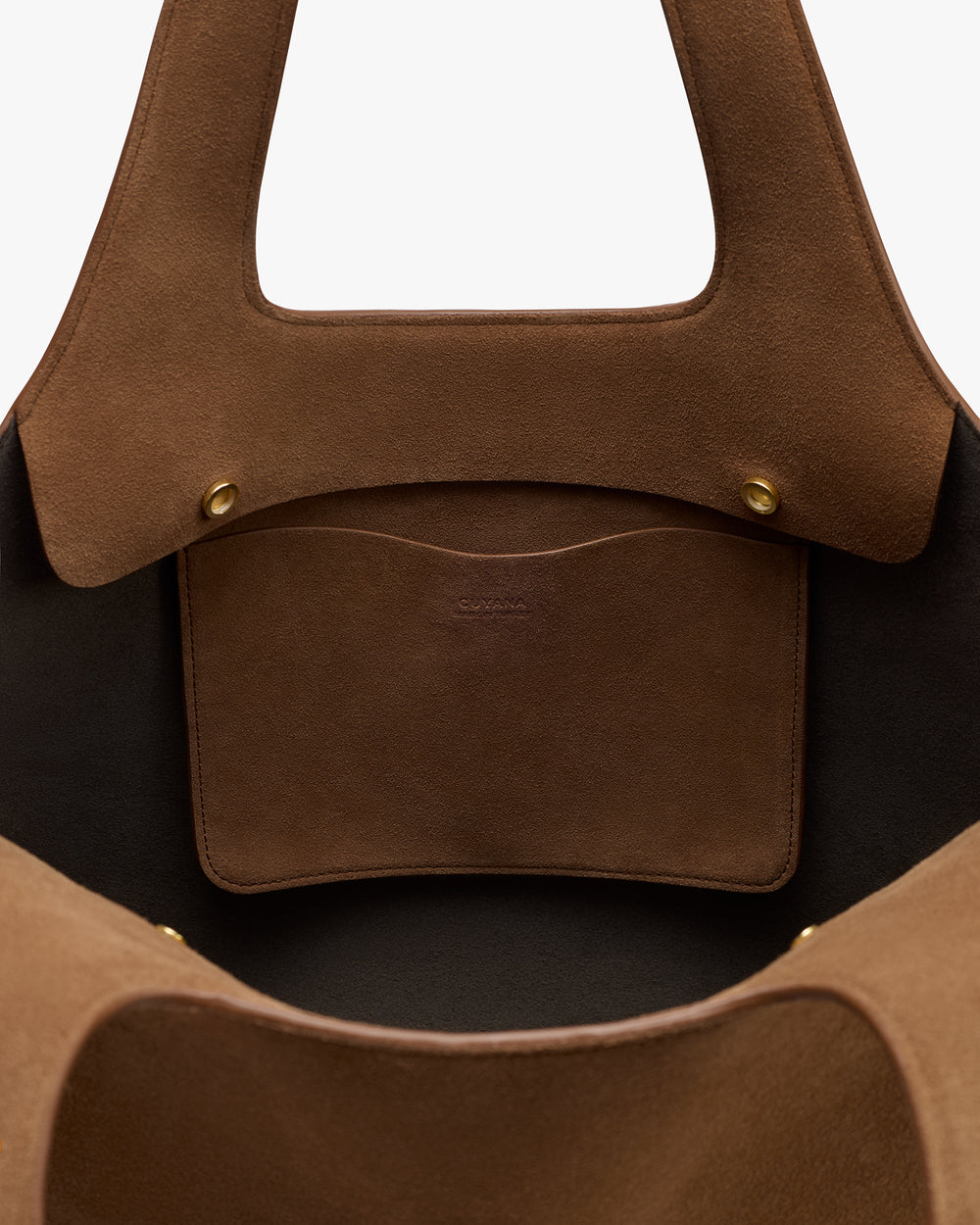 Inside view of an open handbag with a small pocket and snap buttons.