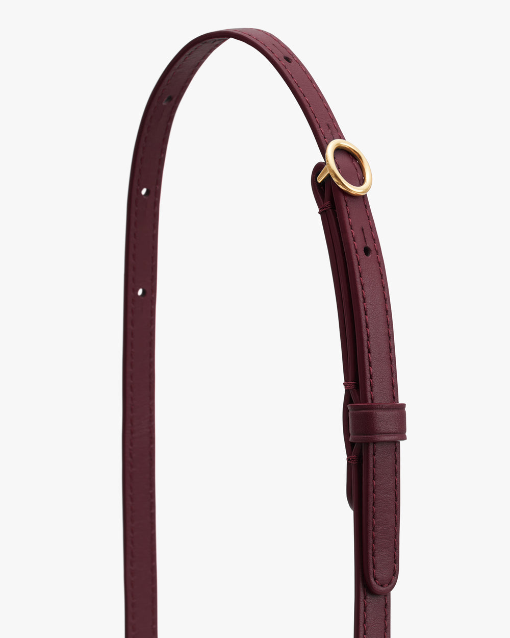Leather belt with circular metal buckle and adjustable holes.