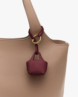 Close-up of handbag with small textured pouch attached to handle.