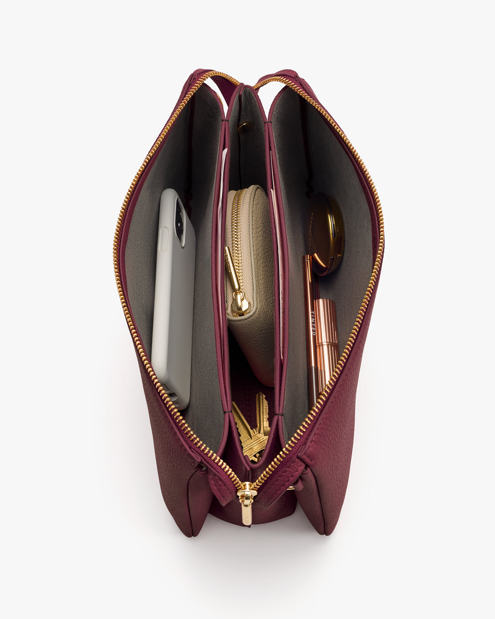 Open handbag with phone, wallet, sunglasses, and lipstick inside.