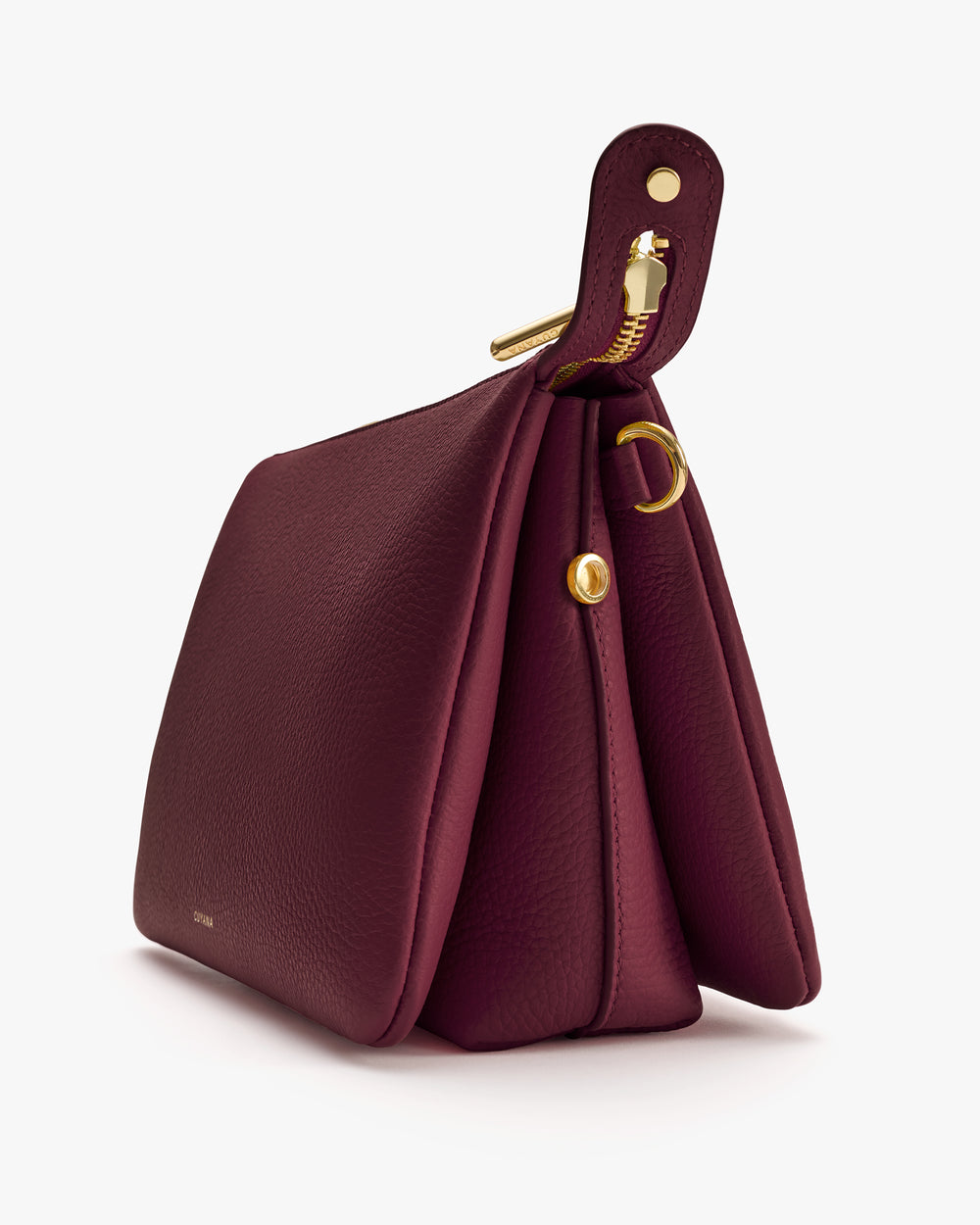 Side view of a structured handbag with gold accents and a top strap handle.