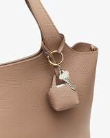 Bag handle with a small pouch and key attached by a ring.