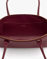 Open handbag with visible interior pocket and handles.