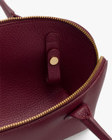 Open handbag with textured interior and zipper closure.