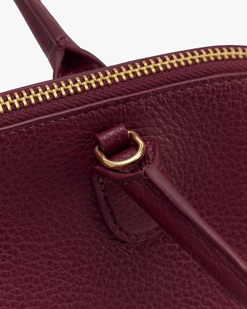 Close-up of a textured bag with a zipper and strap attachment.