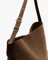 Shoulder strap of a bag with metal buckle detail.