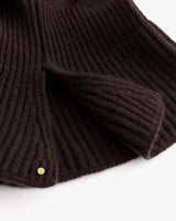 Ribbed knit fabric with a small metal button detail.