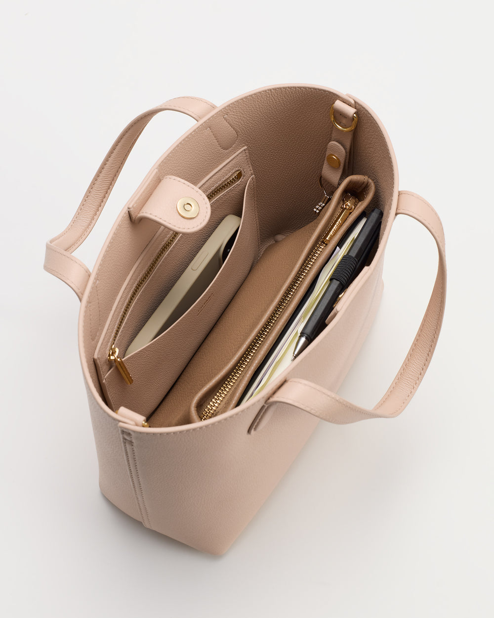 Open handbag with various items inside, including a wallet and a notebook.