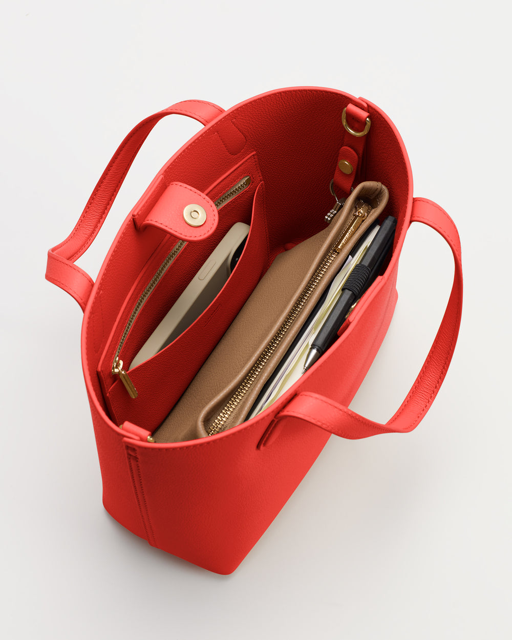 Open tote bag with wallet, phone, and notebook inside.
