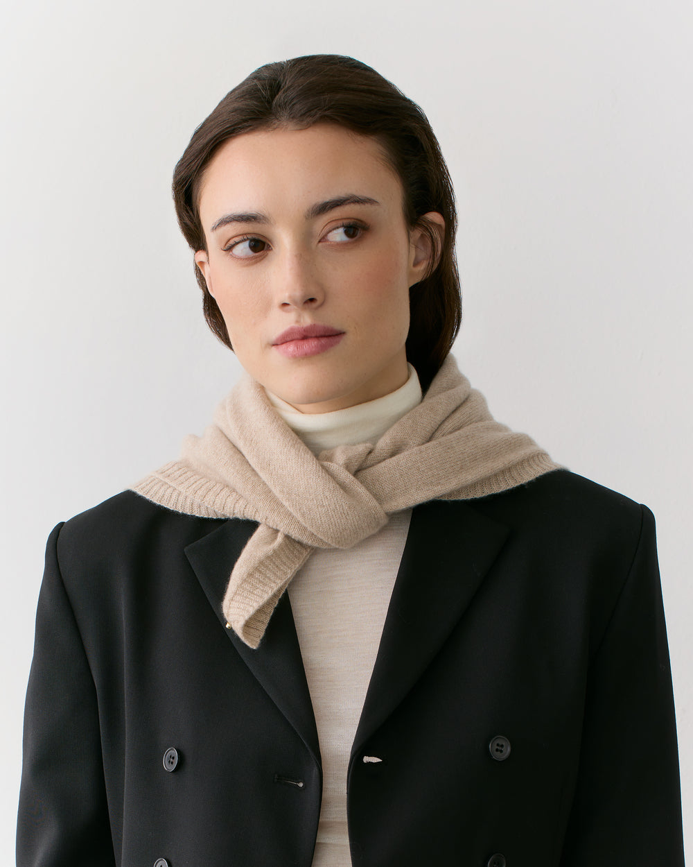 Person wearing scarf and jacket looking to the side