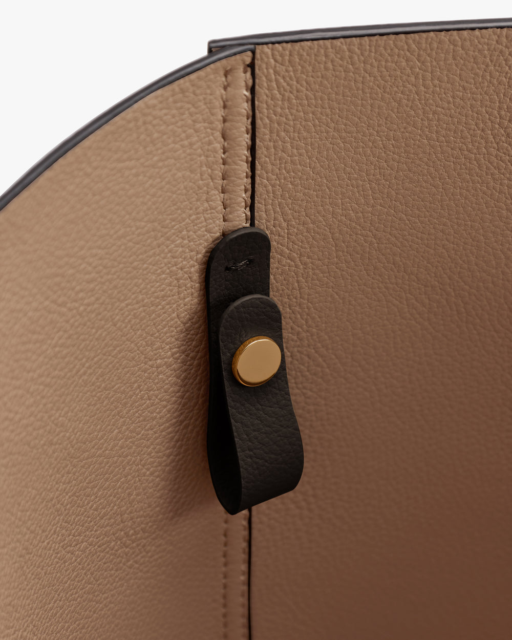 Close-up of a leather bag interior with a buttoned strap.