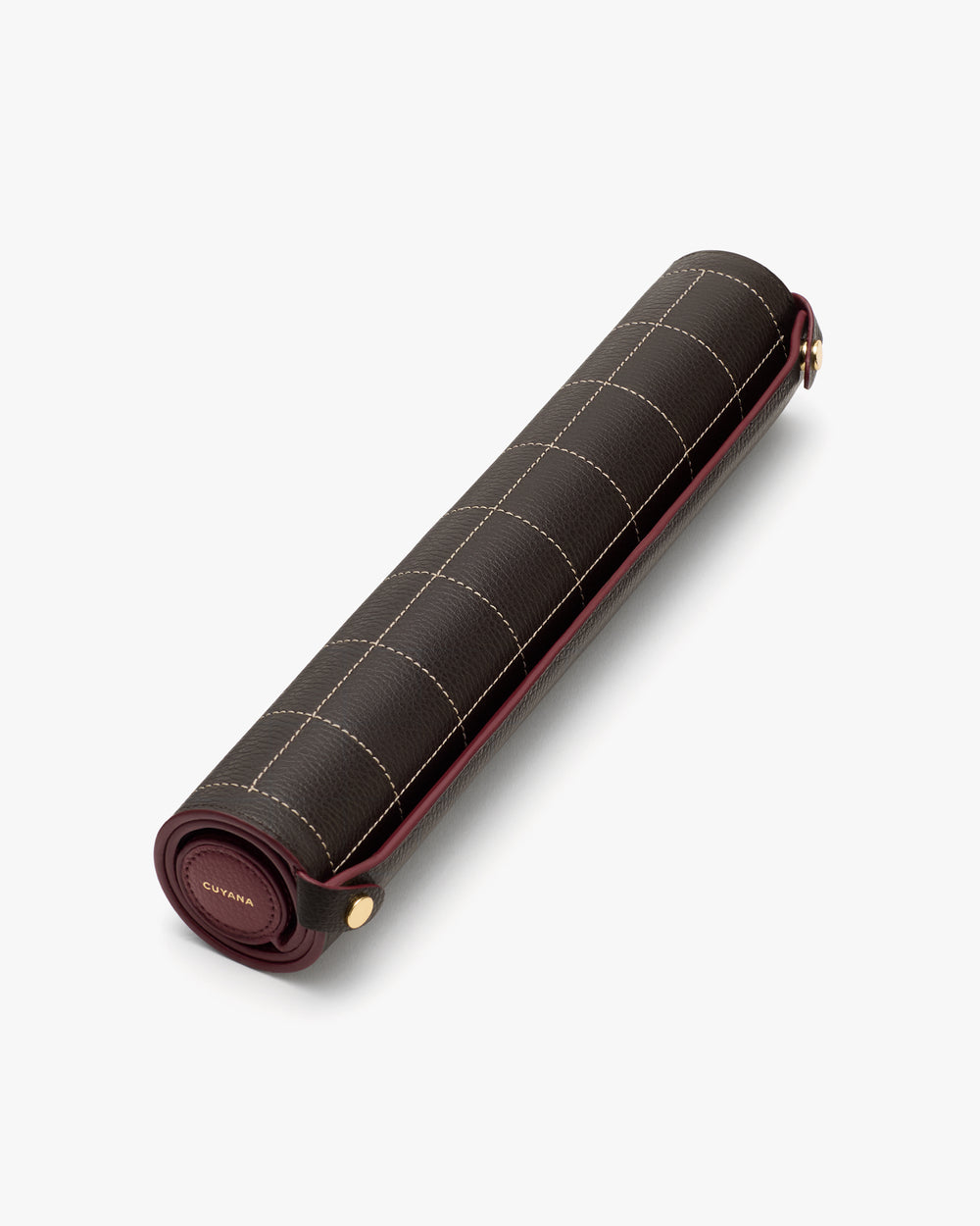 Rolled picnic blanket with grid pattern and leather strap closure.