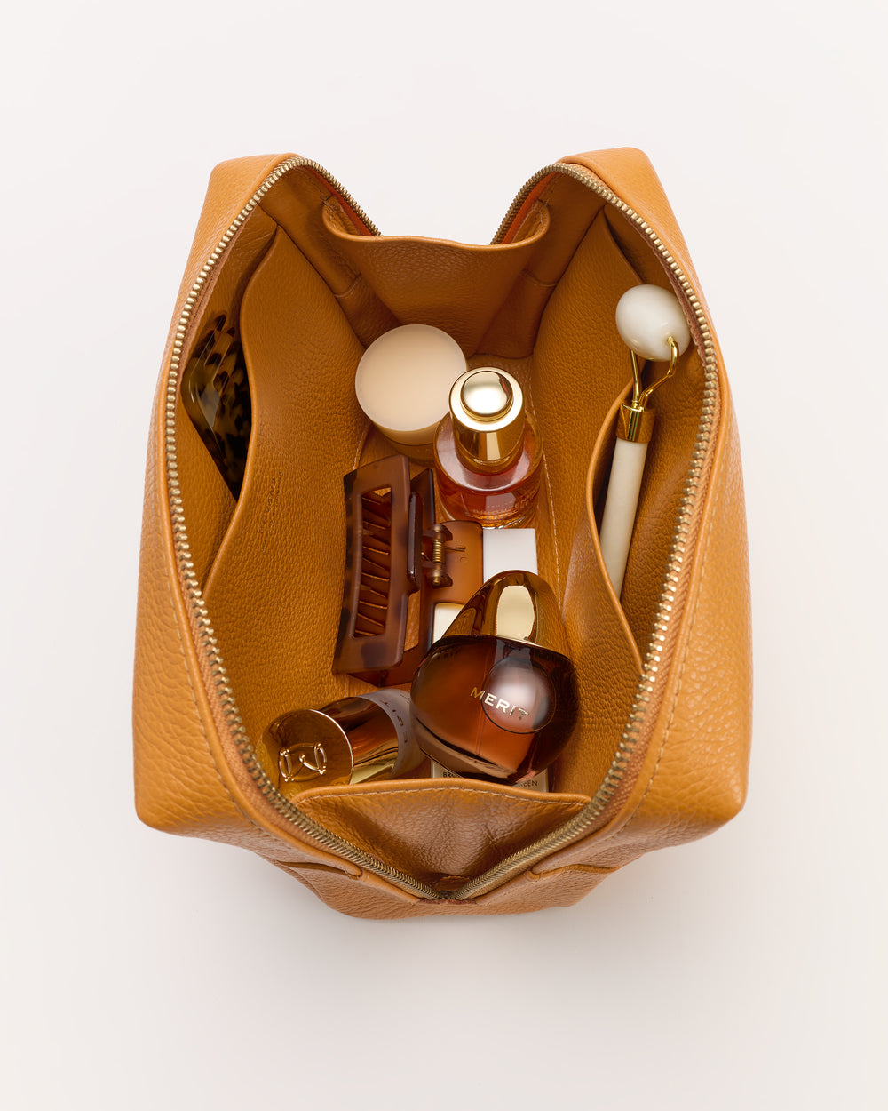 Open toiletry bag with bottles, a brush, and a small container inside.
