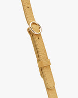 Close-up of a textured strap with a gold buckle.