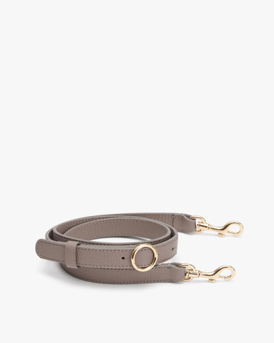 Bag strap with metal clasps and buckle.
