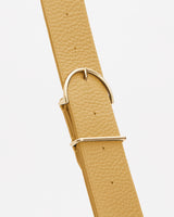 Close-up of a textured belt with a metal buckle.