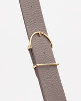 Close-up of a textured belt with a gold buckle.