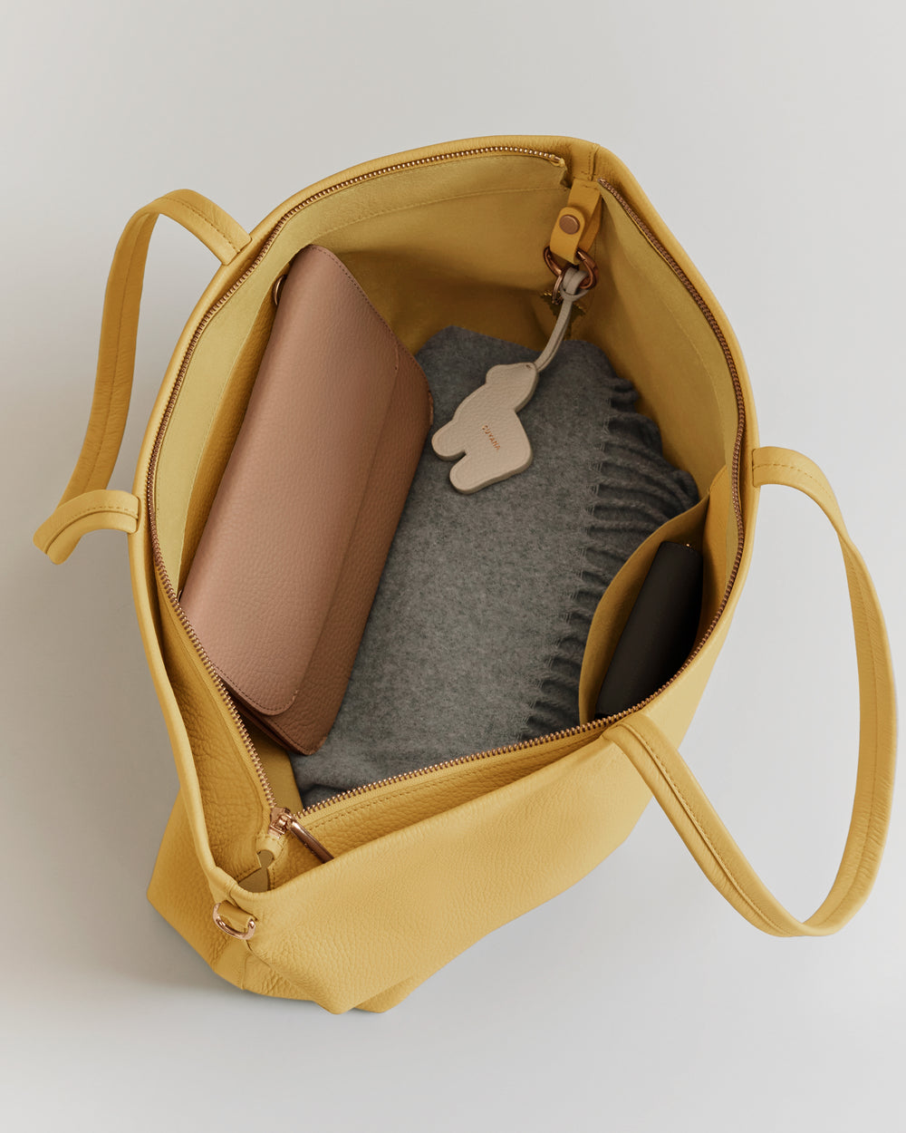 Open bag with a wallet and gray fabric inside.