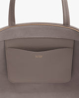 Close-up of an open handbag with an interior pocket.