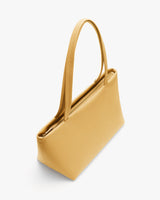 Rectangular handbag with long handles on a plain background.
