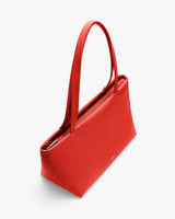 Handbag with long handles and a zippered top opening.