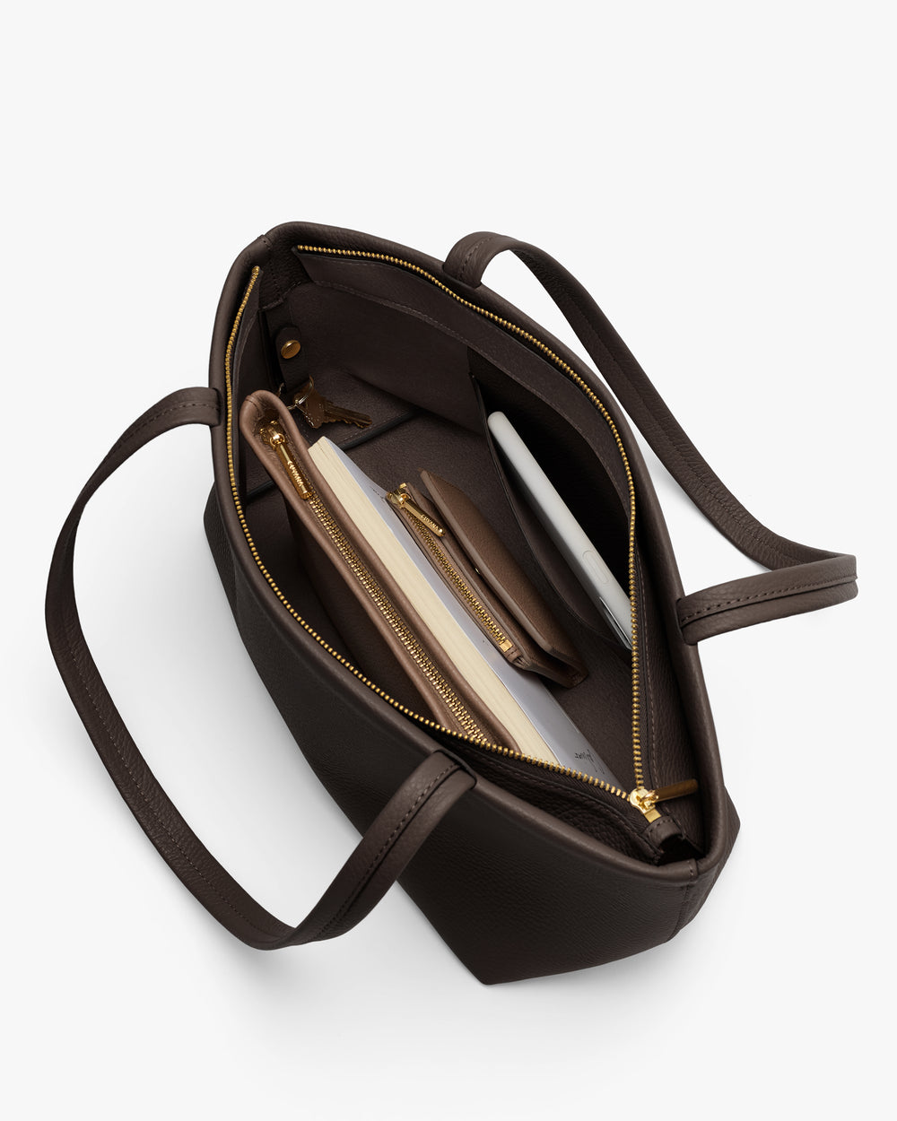 Open tote bag with zipper, holding a laptop, pouch, pen, and small notebook.