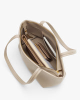 Open handbag with various items inside, including a notebook and a wallet.