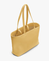 Tote bag with long handles on a plain background.