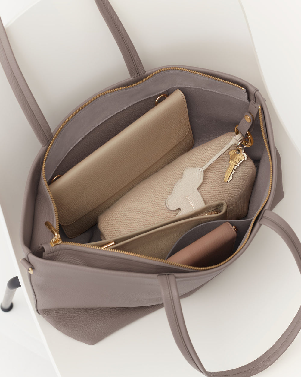 Open travel bag with wallet, pouches, and key inside.