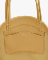 Round handbag with two long handles and an external pocket.