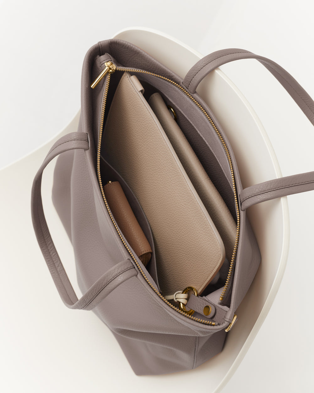 Open handbag with zipper showing multiple pockets.