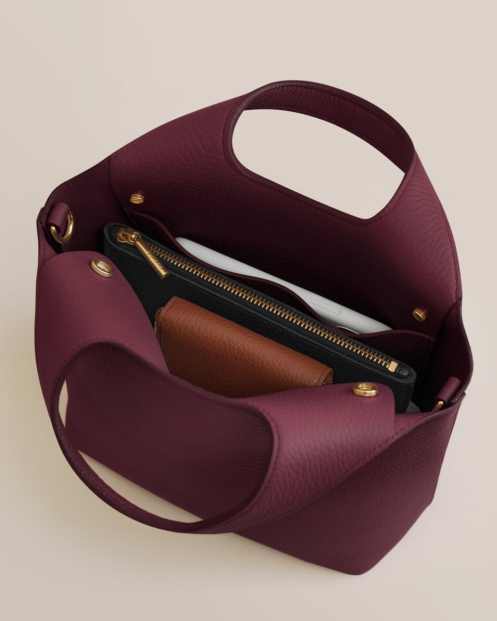 Open handbag with a wallet and zippered pouch inside.