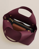 Open handbag with a wallet and zippered pouch inside.