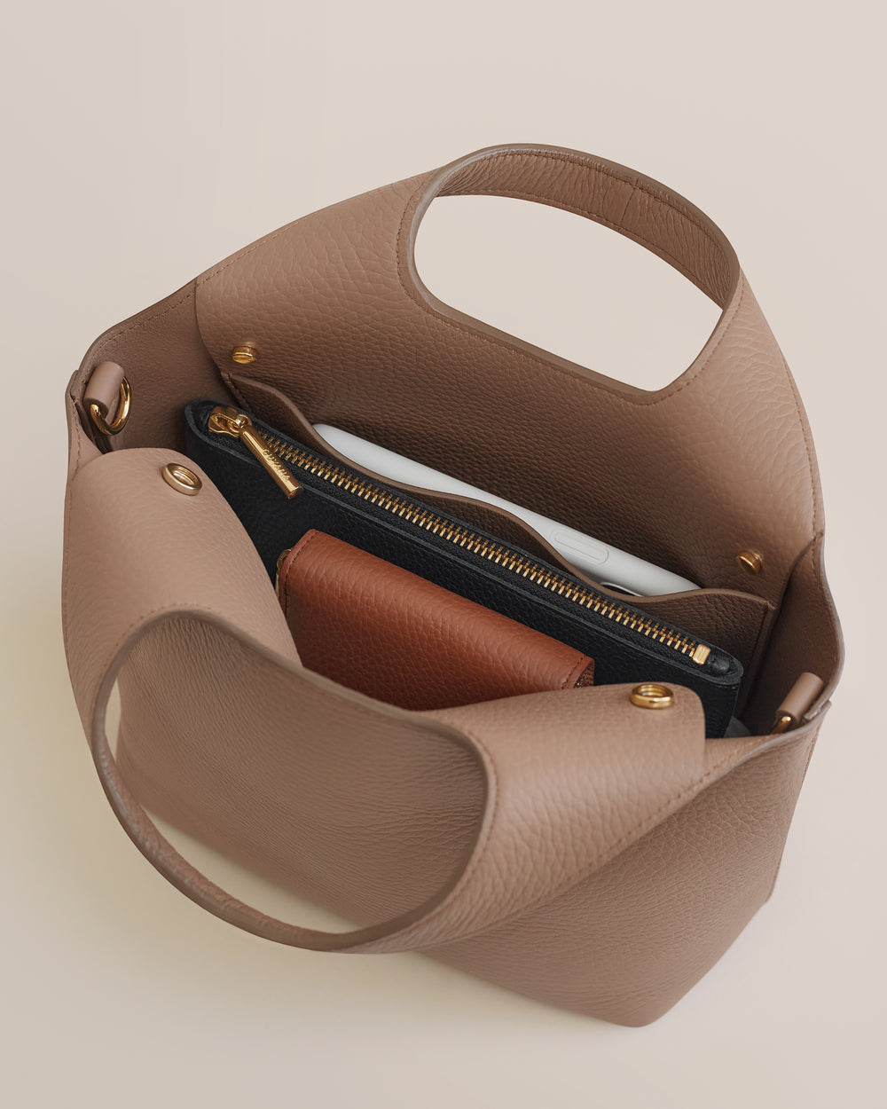 Open handbag with items inside including a zippered pouch and small wallet