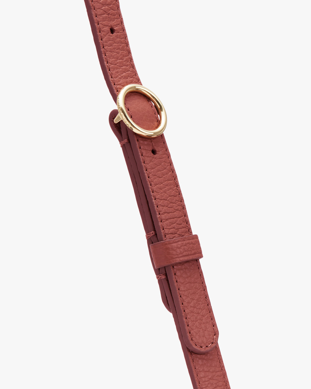Bag strap with a circular metal buckle and adjustable loop.