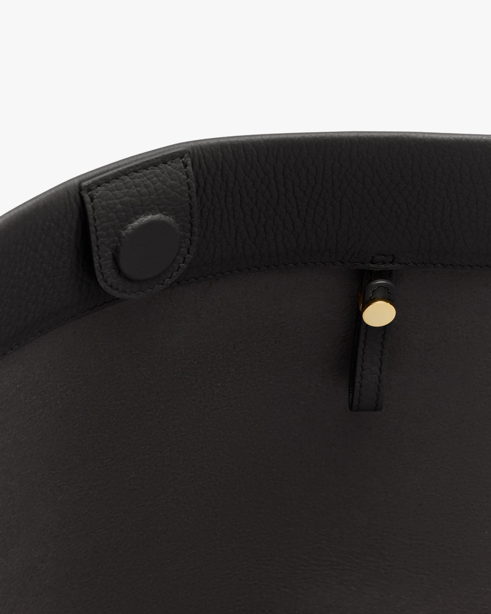 Close-up of a bag's interior with a button and gold stud detail.