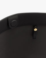 Close-up of a bag's interior with a button and gold stud detail.