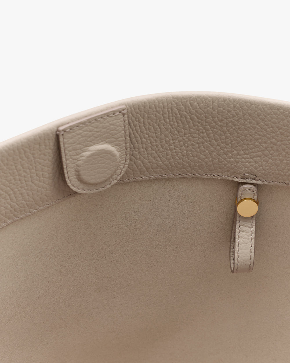 Close-up of handbag interior with button and loop details.