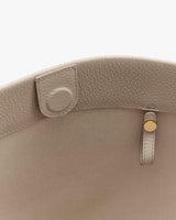 Close-up of handbag interior with button and loop details.