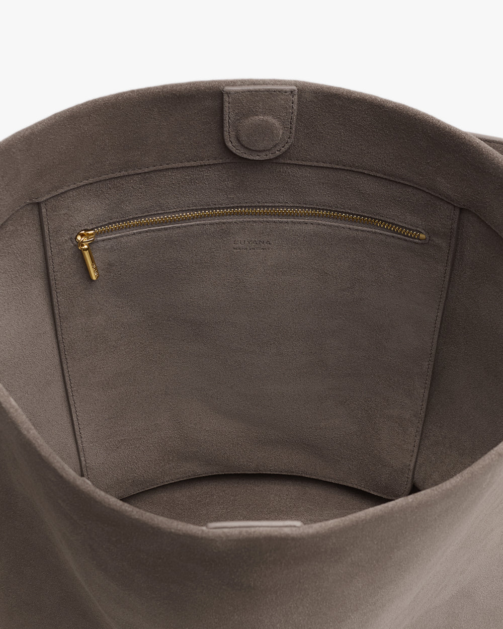 Open bag with an interior zippered pocket and snap closure.