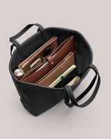 Open tote bag with organized books, wallet, and essentials inside.