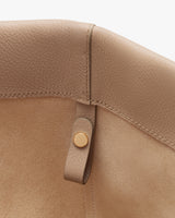 Interior of a bag with a buttoned strap detail.