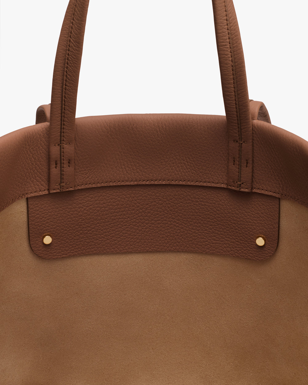 Close-up of a handbag with two handles and gold button accents.