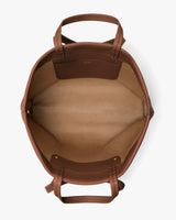 Open top view of an empty travel bag with handles and inner pocket.