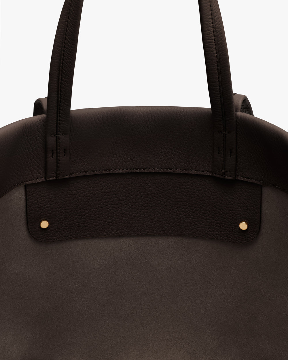 Close-up of handbag with two handles and stud details.