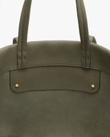 Close-up of a tote bag with two handles and metal rivets.